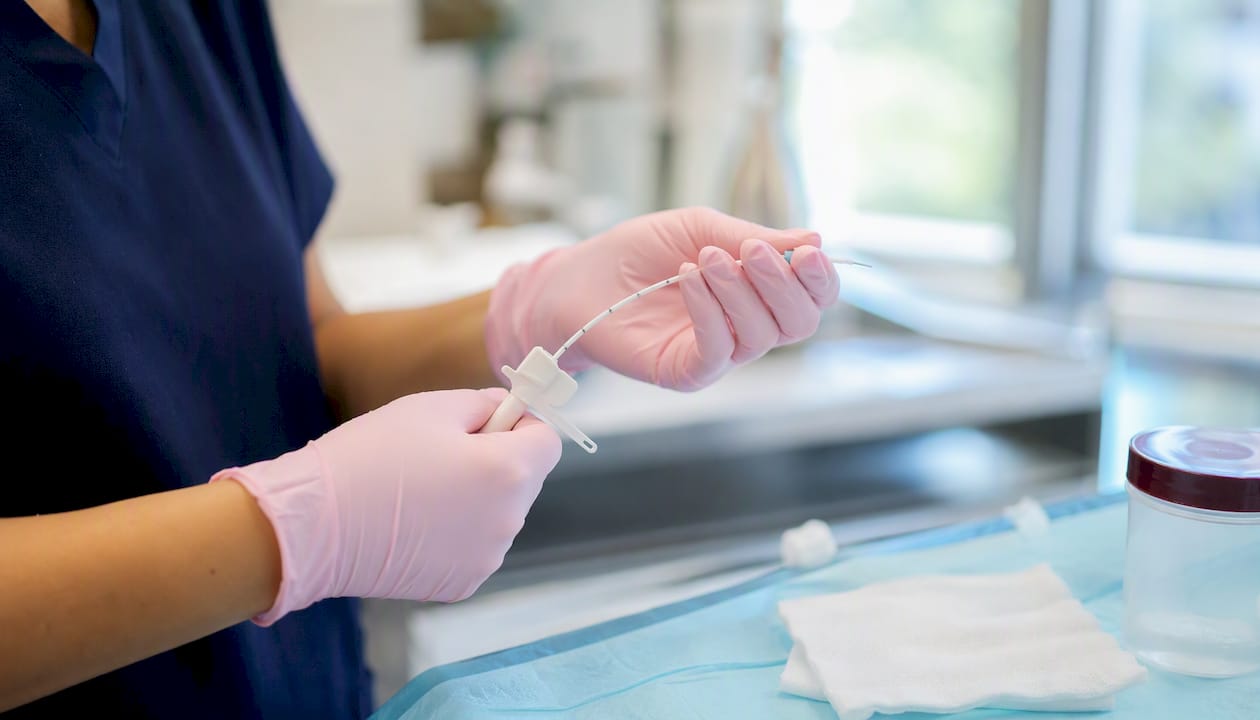 Hands holding biopsy catheter in clinic