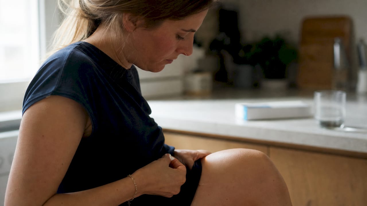 Woman administering progesterone medication at home